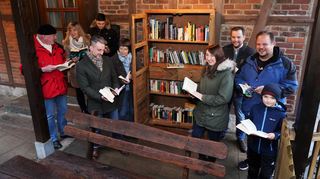 Mitglieder des Schönberger Ortsbeirats und Bücherfans freuen sich über den neuen Bücherschrank, der jetzt am Haus am Dorfplatz aufgestellt und bestückt wurde. Gefertigt wurde der Schrank von einer Bensheimer Schreinerei.