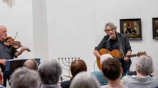 Bernd Köhler (rechts) und Joachim Romeis spielten am Freitag auf Einladung der Geschichtswerkstatt Jakob Kindinger in der ehemaligen Auerbacher Synagoge alte und neuere Widerstandslieder.