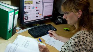 Eine Frau sitzt in ihrem Arbeitszimmer vor dem Computer. Das Finanzamt erkennt die Kosten nur unter bestimmten Voraussetzungen an.