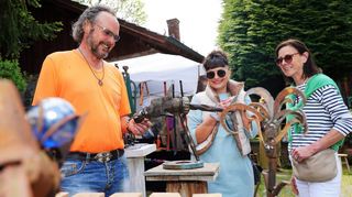 Zwei Besucherinnen bestaunen neugierig den aus Metall gefertigten Hammerhai des Künstlers und Veranstaltungsinitiators Peter Schmitt.
