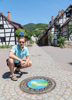 Der Frankfurter Streetart-Künstler Philipp Alexander Schäfer hat in der Scheuergasse einen Kanaldeckel mit dem Motiv der Erdkugel verschönert.