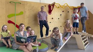 Michaela Schmidt (Leiterin Kita Fuldastraße), Armin Zeißler (Mitte, Leiter Eigenbetrieb Kinderbetreuung) und Daniel von Hauff (Vorsitzender des Fördervereins) freuen sich mit Kindern der „bunten Gruppe“ über die neue Ausstattung im Turnraum.