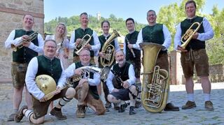 Zünftig in neuer Tracht feiern die Starkenburg Musikanten ihr Zehnjähriges. Hier zeigen sie sich mit den grünen Westen und in Lederhosen in der Kirchengasse mit der Starkenburg im Hintergrund.