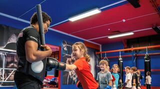 Eine Gruppe der Bensheimer Ferienspielkinder war zu Gast beim KSC Bensheim und durfte Jugendtrainer Morrison Owusu mit Boxhandschuhen „bearbeiten“.