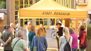 Bei einem Ortstermin informierten Planer und Mitarbeiter der Stadtverwaltung die Anliegerinnen und Anlieger über die zukünftige Gestaltung des Hostinné-Platzes in der Bensheimer Innenstadt.