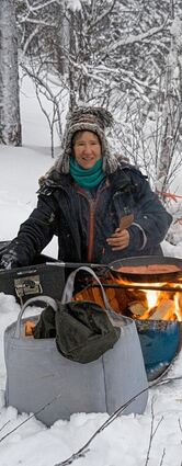 <p>Catherine Marguet brät Fisch am Feuer und bereitet Lachsburger.</p>