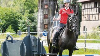 Auf der Trialwiese auf dem elterlichen Hof kann Lilli Jäger auf Primosoro für die „Working Equitation“-Diszilloinen trainieren; dabei muss sie u. a. einen Stab durch den Ring einer Rinder-Figur stechen.