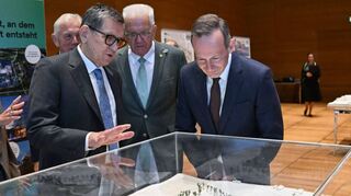 Reinhold Geilsdörfer (v.l.) von der Dieter-Schwarz-Stiftung, Ministerpräsident Winfried Kretschmann und Verkehrsminister Volker Wissing mit einem KI-Park-Modell.