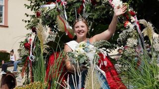 Die Bensheimer Blütenkönigin Charlotte Maschik grüßte von ihrem festlich dekorierten Blütenwagen die Besucher des Winzerfestumzugs.
