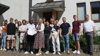 Die katholische Jugend hat mit Projekten zum Aktionsprogramm „Aufholen nach Corona“ beigetragen. Den Förderbescheid für einen Zuschuss gab es nun von der Ersten Kreisbeigeordnete Diana Stolz, die ihn hier an Kaplan Valentine Ede überreicht; rechts Dekan Thomas Meurer, Leiter des Pastoralraums.