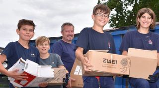 Die Freiwilligen luden die gesammelten Kartons in einen Container.