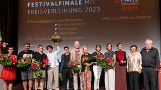 Mit den Preisträgern (v. l.) Alice Gruia und David Wnendt freuen sich die Jury (Mitte) sowie Programmleiterin Daniela (2.v.r.) und Intendant Michael Kötz (r.).