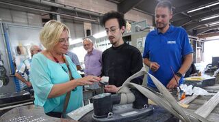Birgit Heitland ließ sich von Bildhauer Mikail Caliskan (Mitte) sowie Verkaufsleiter und Prokurist Nicolai Back (rechts) die moderne und kunstvolle Grabsteinproduktion bei Destag zeigen.