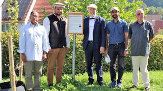 Ein Schild weist nun auf den „Friedensbaum“ (ganz links) auf dem Spielplatz „Am Teufelsbach“ hin. Feierlich enthüllt wurde das Schild von Muhammed Ishaq (Regionalvorsitzender der Ahmadiyya-Gemeinde), Imam Murtaza Mannan, Bürgermeister Andreas Heun, Initiator Waleed Cheema und Ortsvorsteher Walter Kirschbaum (von links).