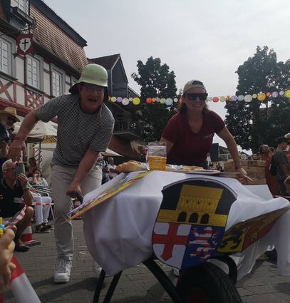 Jana Lenhart, Leiterin des Kulturbüros, bildete mit dem Zwevegemer Bürgermeister Marc Doutreluingne ein Team beim Schubkarren-Rennen. Auch die Bürger-Funken (r.) mit Sascha Günthner und Freddy Kaupa balancierten Bier, Baguette und belgische Waffeln schnell über den Parcours. Sieger aber wurde das Einhäuser Team.
