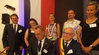 Bürgermeister Schönung und sein belgischer Amtskollege Doutreluingne unterzeichnen das erneuerte Versprechen.