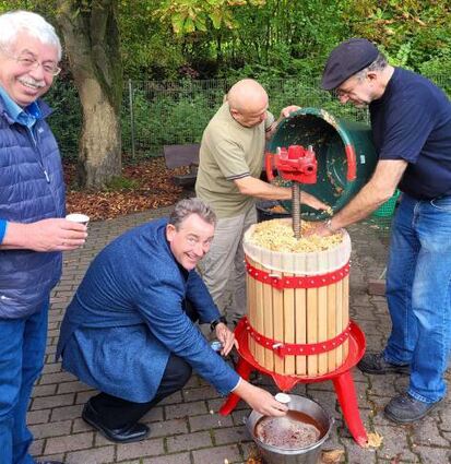 Vorsitzender Klaus Eberle zeigt, wie Äpfel zu Saft gekeltert werden.