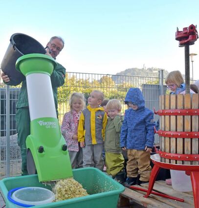 Gesunde Ernährung spielt in Heppenheimer Kitas eine wichtige Rolle. Die Kinder der „Räuberhöhle“ durften Gerd Müller zuschauen, wie die Äpfel, gefüllt in den Häcksler, zerkleinert herauskommen und der leckere Saft entsteht.