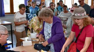 Pfarrer Klaus Rein, links, kassierte beim Kerwecafé im katholischen Pfarrzentrum das Geld für den Verkauf von Kaffee und Kuchen.