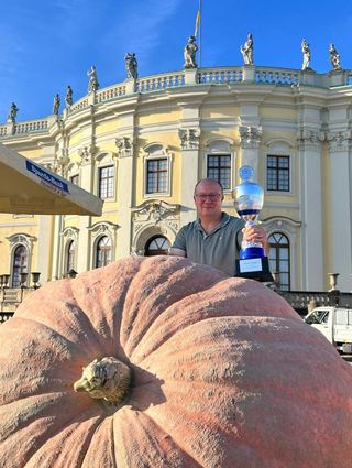 Matthias Würsching und sein Kürbis vor dem Ludwigsburger Schloss mit Pokal.