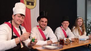 Kerbvereinsvorsitzender Christian Pfeifer (mit Kochmütze) präsentiert einen „Linnefelser“ (ein scharf gewürzter Wackelpudding mit einem Pommes-Frites-Stäbchen). Neben ihm das Kerbgericht mit Sebastian Kredel sowie Laurin und Ariane Ehrhardt (von links).