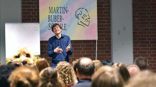 Moritz Becker referierte vor Eltern in der Aula der Martin-Buber-Schule über die Möglichkeiten und Gefahren von Instagram, TikTok und Co.
