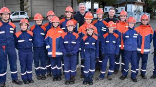 Antritt der Jugendfeuerwehr Einhausen, bestehend aus fünf Mädchen und zehn Jungen, mit Bürgermeister Helmut Glanzner (hinten links) und Gemeindejugendfeuerwehrwart Florian Röll (hinten rechts), vor der Inspektionsübung zur Rettung von Menschen aus einem brennenden Gebäude.