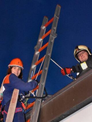 Frida Götz stieg mit einem Schlauch und gesichert auf das Feuerwehrhaus.