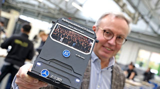 Die Azubis schenken Jürgen Hartwig einen Truck aus dem 3D-Drucker.