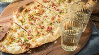 Flammkuchen braucht richtig Feuer, das heißt Hitze. Er sollte mindestens bei 250 Grad Ober- und Unterhitze backen. Das sorgt dafür, dass er Blasen wirft und so schön knusprig wird.