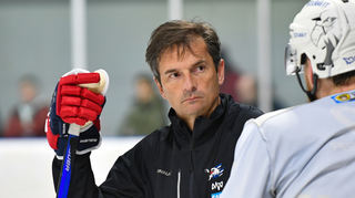 Adler-Trainer Dallas Eakins stellt sich vor seinen gesperrten Spieler David Wolf.