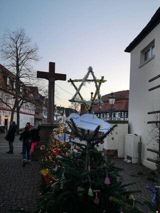 Am Lorbacher Haus sind die Kindergärten mit ihren schmucken Bäumen präsent. Hinter dem Kreuz kann man unter anderem auch einen Davidstern sehen.