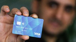 Ein Geflüchteter hält eine Debitcard in der Hand. Der Ortenaukreis hat die ersten Bezahlkarten für Geflüchtete ausgeben. Auch im Kreis Bergstraße wird über ein ähnliches System nachgedacht.