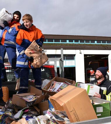 Mitglieder der Jugendfeuerwehr und der Bereitschaft beim Umladen des Papiers von einem Lastwagen in den Container.