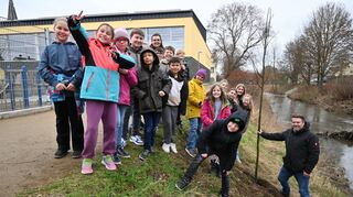Die Kinder erfuhren, dass ihr Bäumchen bis zu 30 Meter hoch und 1000 Jahre alt werden kann. Hinten Klassenlehrerin Bettina Lautenschläger, rechts Florian Schumacher mit der Linde, die noch durch einen Zaun vor dem Biber geschützt wird.