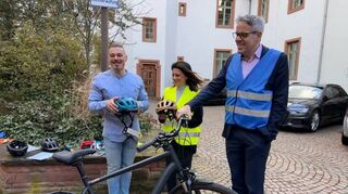 Landrat Christian Engelhardt demonstriert mit Marvin Molitor (Fahrradexperte, links) und Lisa-Marie Riemann (Abteilung Personennahverkehr und Mobilität, mitte) an seinem eigenen Rad, was jetzt im Frühling wichtig ist