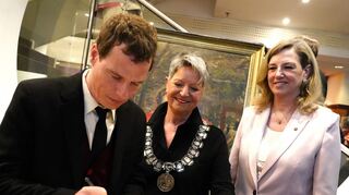 Eintrag ins Goldene Buch der Stadt Bensheim: Eysoldt-Preisträger Jörg Pohl verewigt sich, beobachtet von Bürgermeisterin Christine Klein und Stadtverordnetenvorsteherin Christine Deppert (re.).