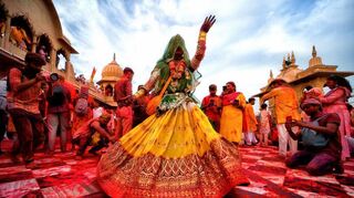Eine Frau tanzt zu Holi im Tempel von Barsana.