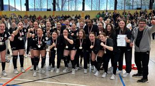 Nationalspieler Juri Knörr (li.) überreichte den Meisterpokal an die weibliche A-Jugend der HSG Bensheim/Auerbach.