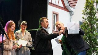 Stadtverordnetenvorsteher Andreas Kovar (li.) und Bürgermeister Holger Habich (re.) stimmten während der regnerischen Eröffnung des Bacchanals am Freitagabend gemeinsam „Singing in the Rain“ an.