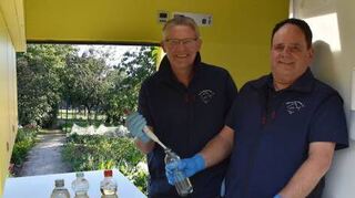 Matthias Ahlbrecht (l.) und Frank Sombrowski untersuchen Proben von Brunnenwasser.