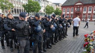 Minuten nach dem Bekanntwerden seines Todes trauern Polizisten auf dem Marktplatz in Mannheim um ihren getöteten Kollegen. Der Polizist war hier von einem Mann mit einem Messer niedergestochen und lebensgefährlich verletzt worden. Bild: Boris Roessler/dpa