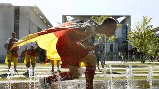 Abkühlung nötig: Ein Deutschland-Fan erfrischt sich in einer kleinen Fontäne auf dem Fanfest vor dem Bundeskanzleramt in Berlin bei der WM 2006.