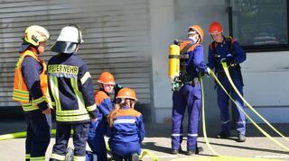 Der Feuerwehrnachwuchs macht sich bereit für den Einsatz unter Atemschutz in der verqualmten Werkstatt.