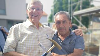Hans-Werner Beckert (l.), einer der Wohnungseigentümer, beschenkte Polier Simon Vachtanidis mit einem goldenen Maurer-Hammer.