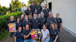 Stifterin Vanessa Fath (sitzend Zweite von rechts) überreicht dem Verein zur Erhaltung der Zwingenberger Traditionskerb den neuen Pokal.