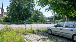 Der bisherige Parkplatz soll abgesenkt und darüber eine zweite Parkebene gebaut werden, um den Platz für Fahrzeuge zu verdoppeln und die Parksituation im Zentrum zu entspannen.