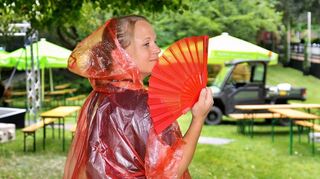 Pressesprecherin Iris Kühn zeigt’s: Mit Poncho und Fächer können sich die Festspielbesucher auf – fast – alle Wetterlagen einstellen.