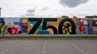 Das Jubiläumslogo ziert als Streetart-Werk nun eine Lärmschutzwand entlang der Bahngleise.