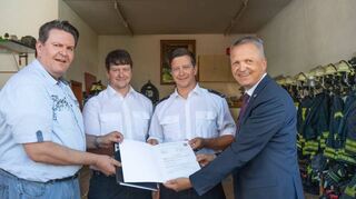 Überreicht wurde der Förderbescheid durch Staatssekretär Martin Rößler (rechts) an Wehrführer Tobias Pfeifer (Zweiter von rechts) und seinen Stellvertreter Christian Pfeifer (Zweiter von links) sowie Bürgermeister Michel Helbig.
